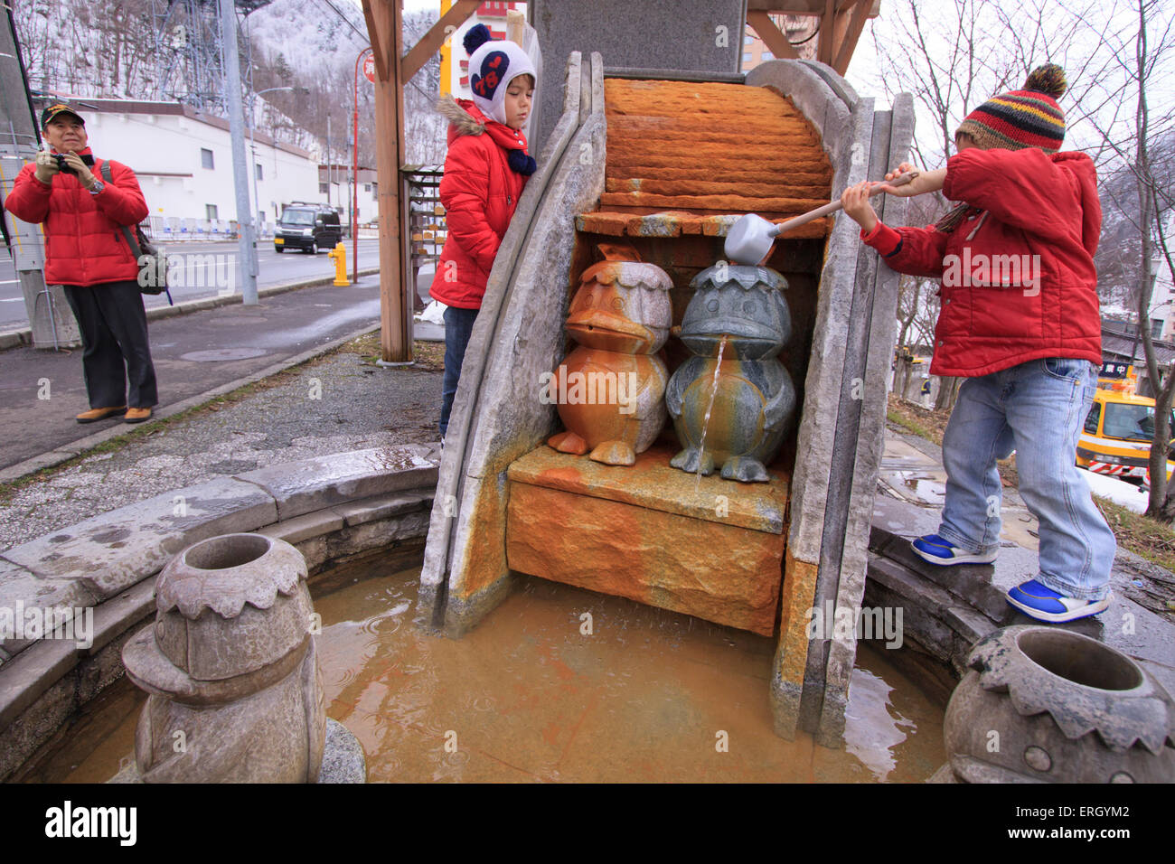 Ein kleiner Junge gießt Wasser zu verschütten aus dem Mund von einem Kappa,  Wassergeist, Statue in Jozakei, Sapporo, Hokkaido, Japan Stockfotografie -  Alamy