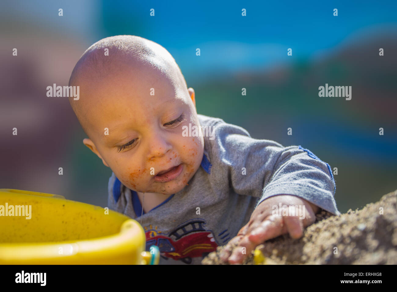Baby Boy zum ersten Mal im Sandkasten spielen. Stockfoto