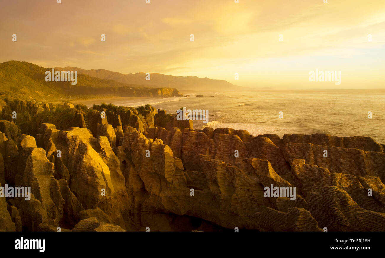 Panaroma von Pancake rocks in die malerische Aussicht auf Berge, Strand und Sonnenuntergang. Stockfoto