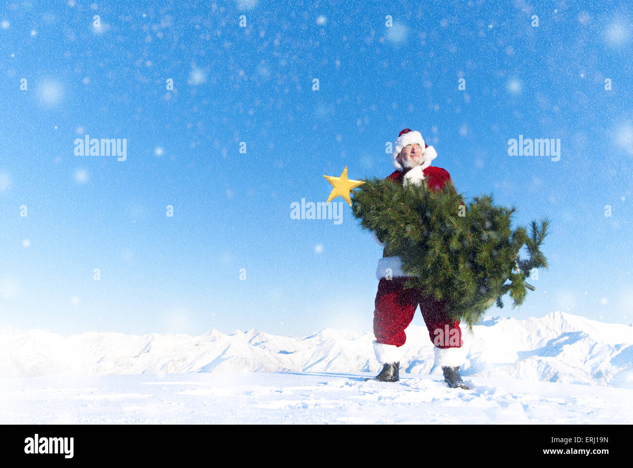 Weihnachtsmann mit Tannenbaum auf Schnee Berg bedeckt. Stockfoto