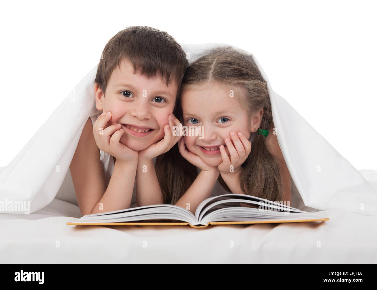 Kinder lesen ein Buch im Bett unter der Decke Stockfoto