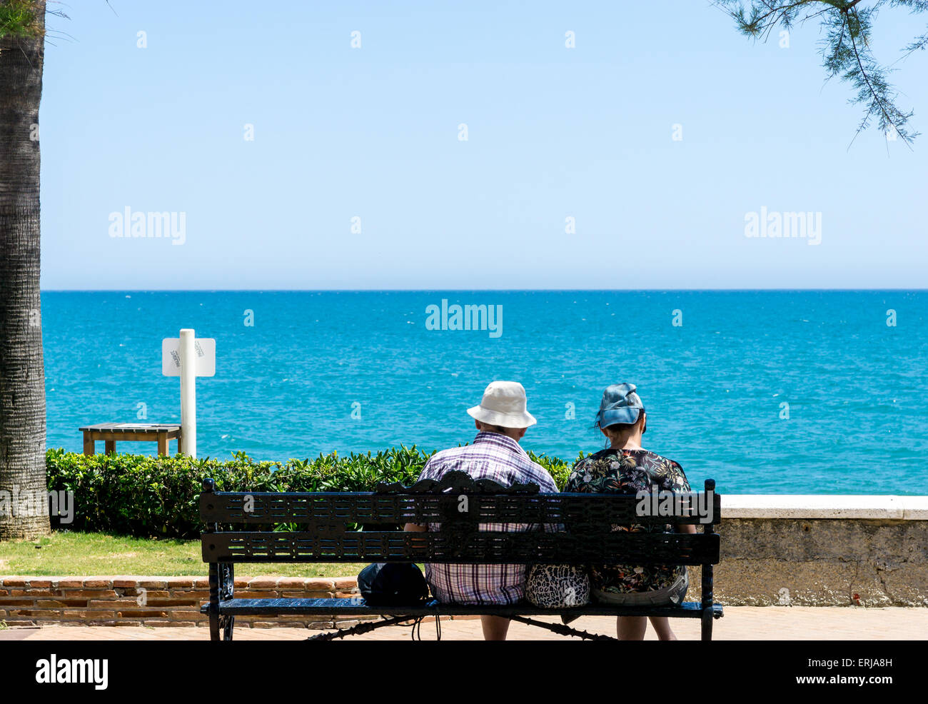 Zwei Senioren auf einer Bank, Blick auf das Meer in Fuengirola, Andalusien, Costa Del Sol, Spanien. Stockfoto