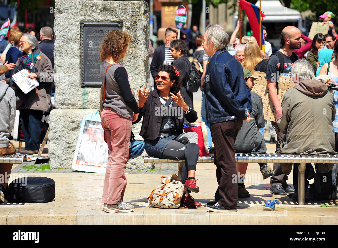 Eine sitzende Frau gestikuliert mit anderen bei einem Protest im Zentrum von Bristol. Stockfoto