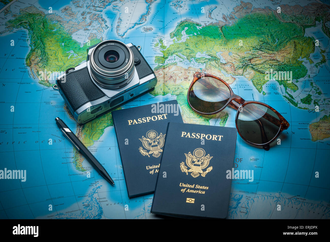 Pässe für Weltreisen, Kamera und Gläser auf einer Karte der Welt Stockfoto