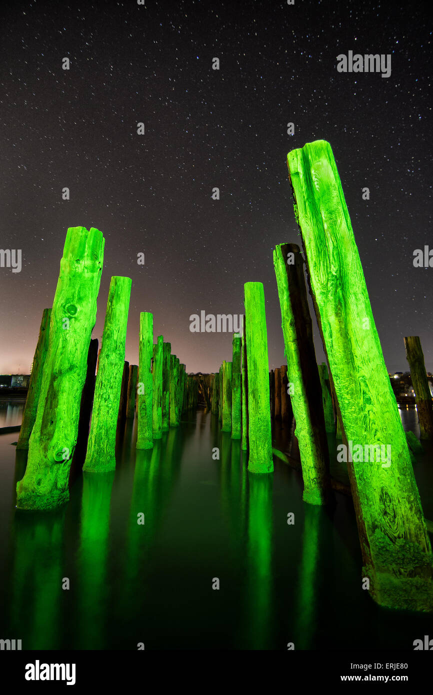 Ungewöhnliche grüne Stangen in der Wasserreflexion in der Nacht mit tiefen Sterne Himmel Stockfoto