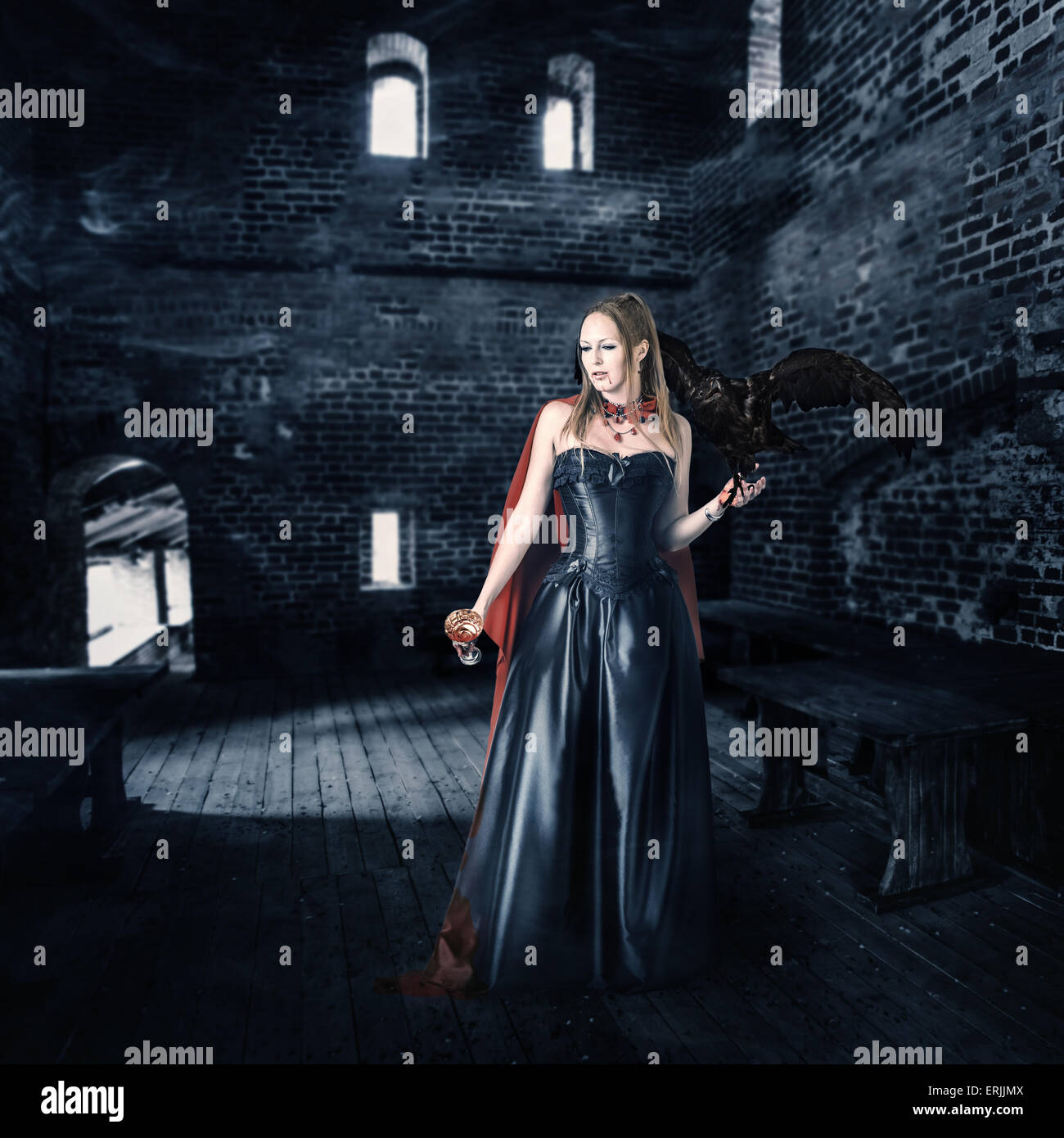 junge schöne weibliche Vampir Aristokrat mit einer Tasse Blut steht in