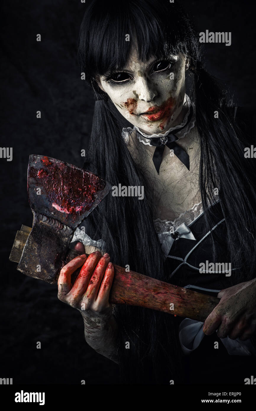 Tote weibliche Zombie mit blutigen Axt reicht die Hand geschossen. Halloween Horror. Böser Geist mit schwarzen Augen Stockfoto