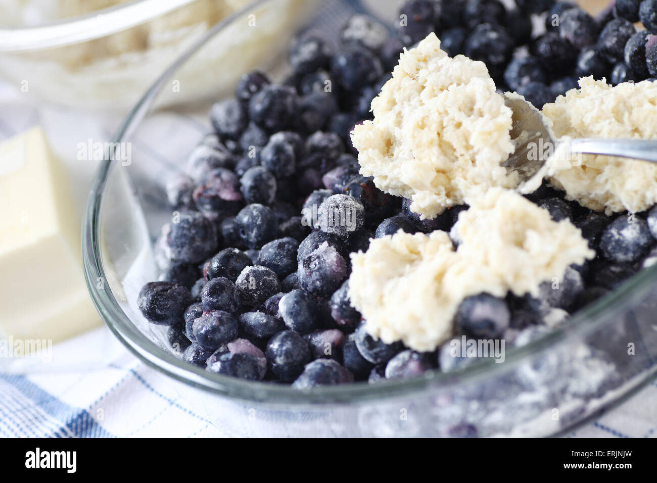 Löffelt Plätzchenteig auf eine Schüssel mit gezuckerten Heidelbeeren Stockfoto