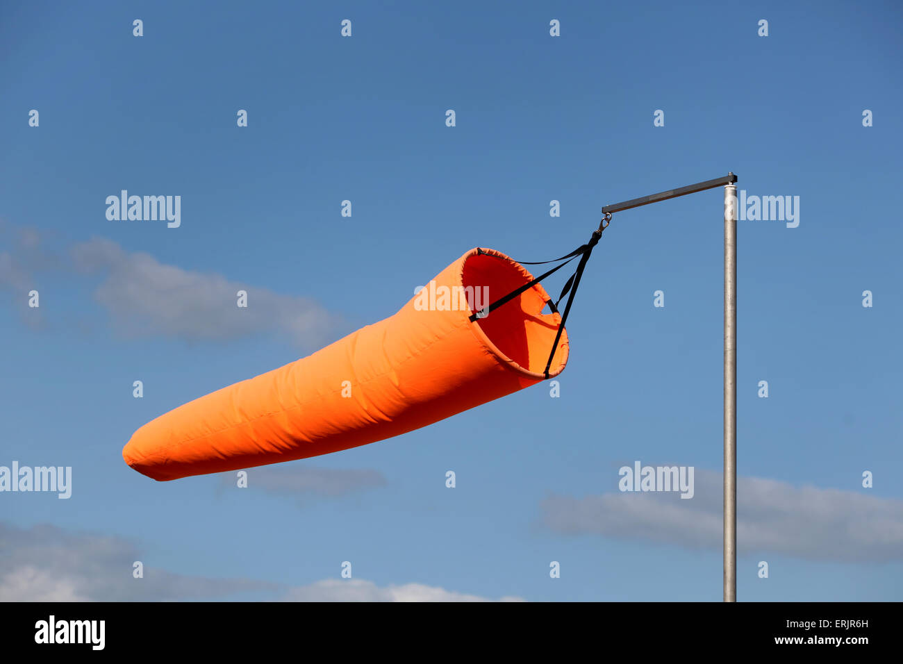 leuchtend orange Windsack im Wind vor blauem Himmel Stockfoto