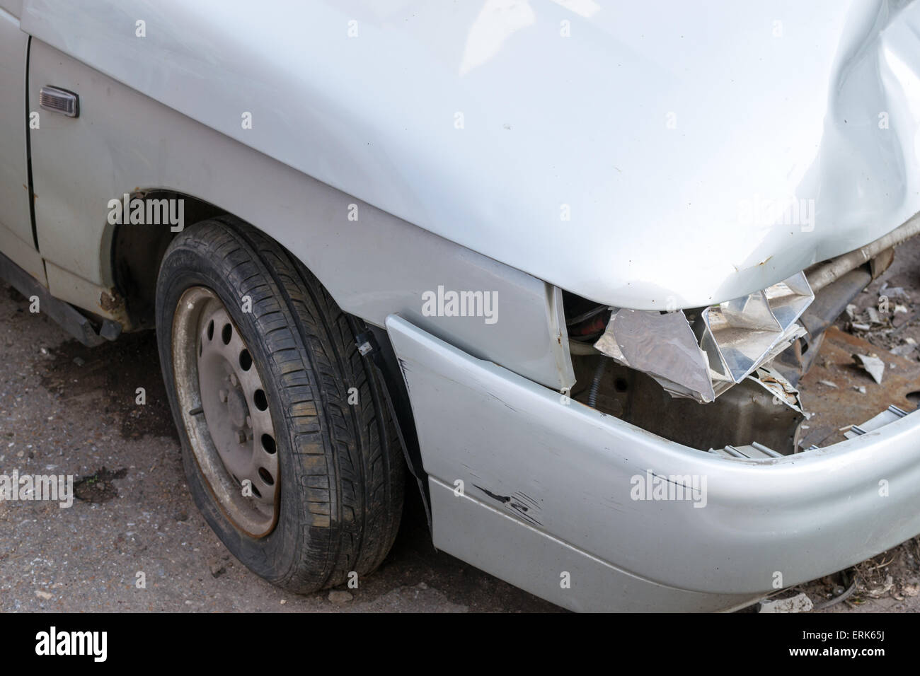 Einzelne defekte Scheinwerfer auf eine stationäre Silber Limousine und Reifenpanne Stockfoto