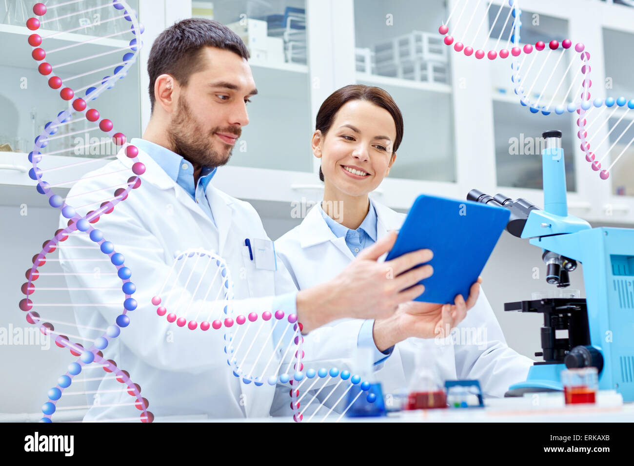 Wissenschaftler mit TabletPC und Mikroskop im Labor Stockfoto
