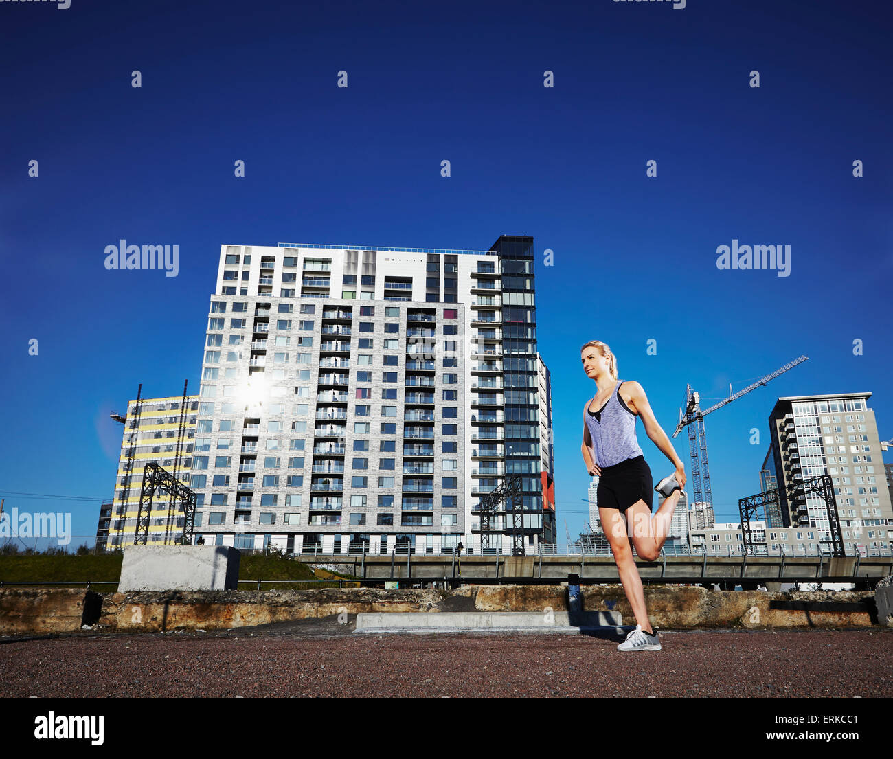 Weibliche Läufer dehnen vor einem Lauf in einem städtischen Umfeld; Montreal, Quebec, Kanada Stockfoto
