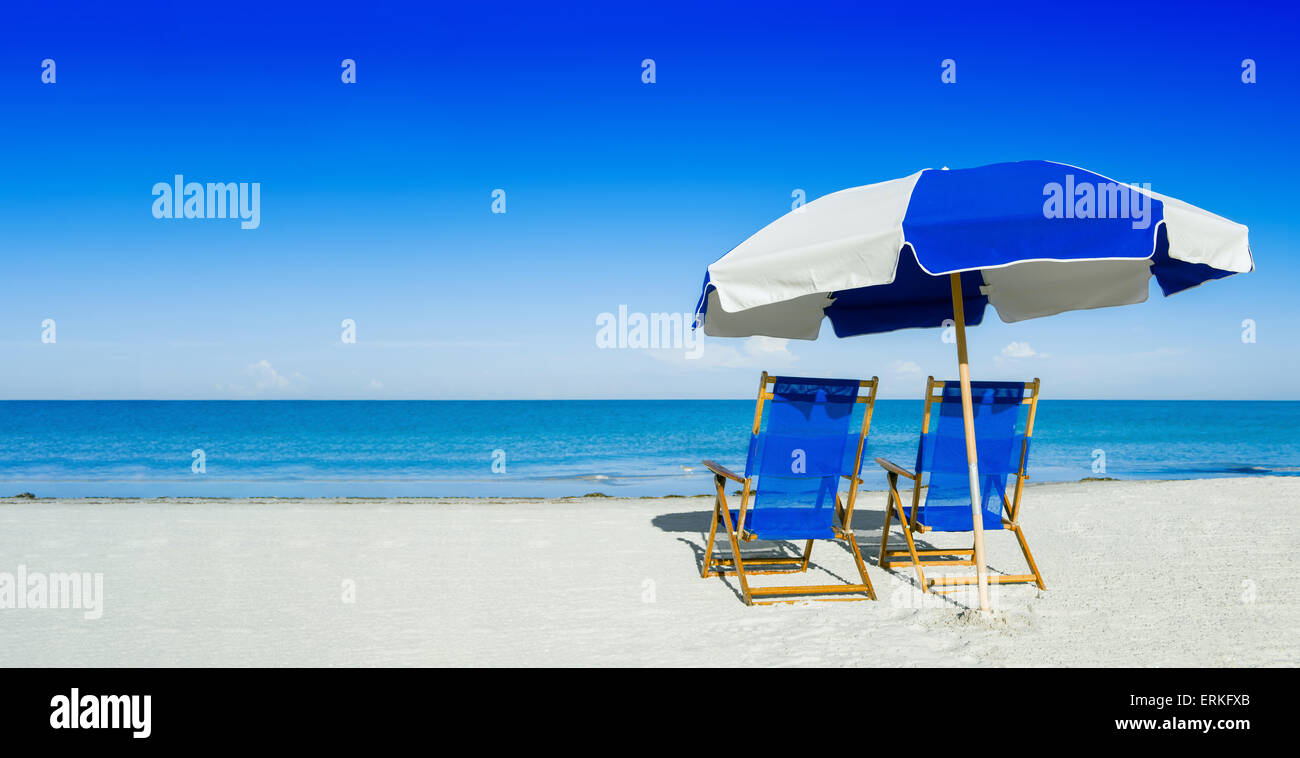 Liegestühle und ein Sonnenschirm auf silbernen Sand, Urlaub-Konzept Stockfoto