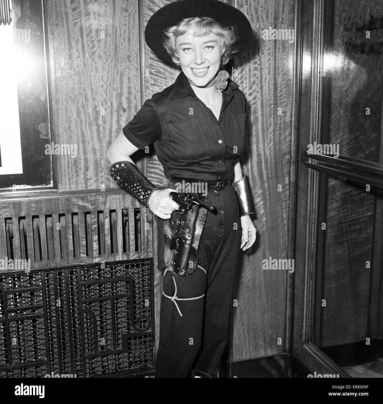 Premiere der Cowboy im Odeon Leicester Square. Schauspielerin Glynis Johns Hods a Pistole in das Holster. 24. Januar 1958. Stockfoto