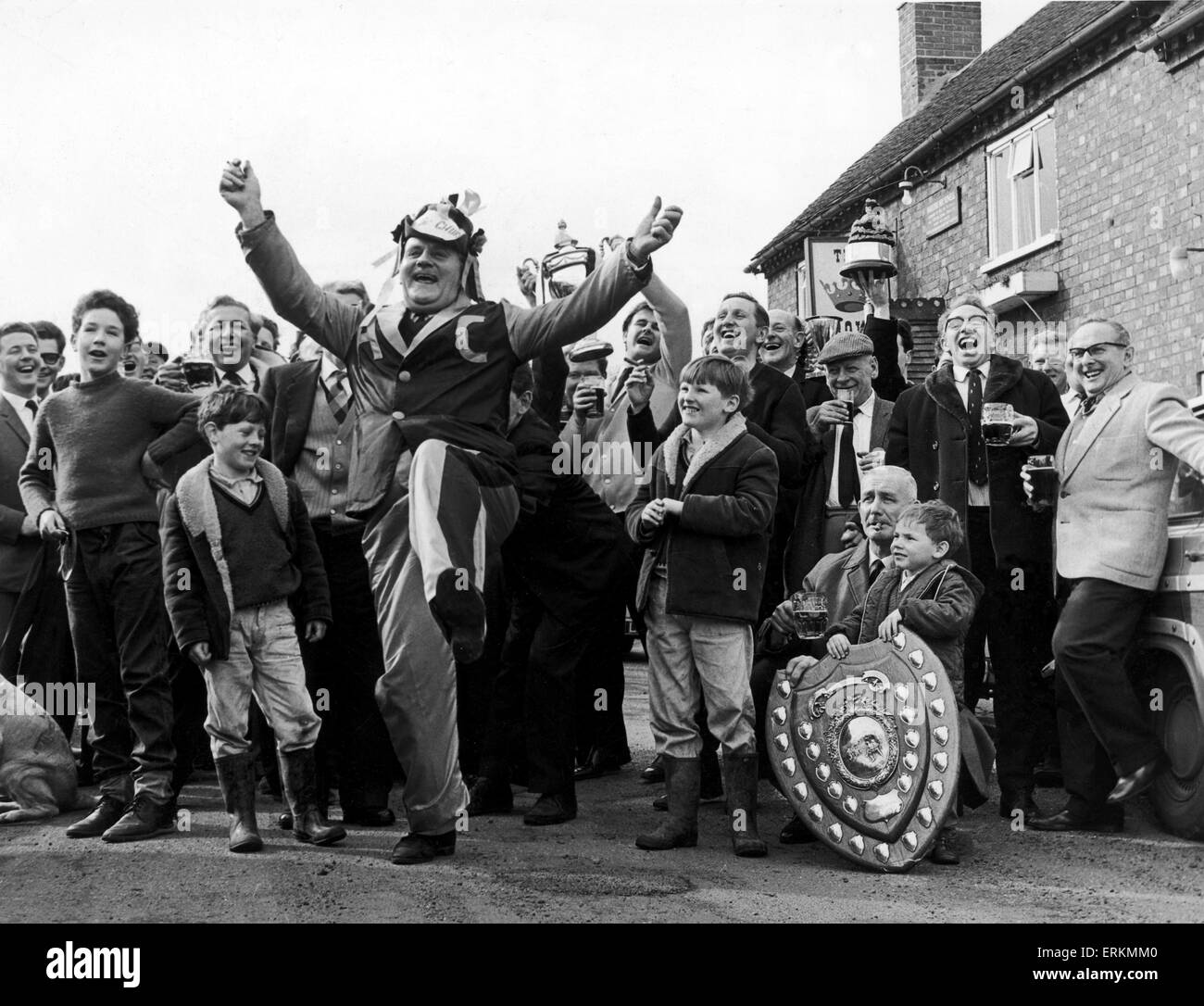 Glückliche Tage für Alvechurch Fans. Maskottchen Tom Borrows führt die Feierlichkeiten vor der Krone Pub, Club Hauptquartier nach dem Worcestershire Kombination Team Sieg über Crook Town, das FA Amateur Cup-Halbfinale zu erreichen. 7. März 1966. Stockfoto