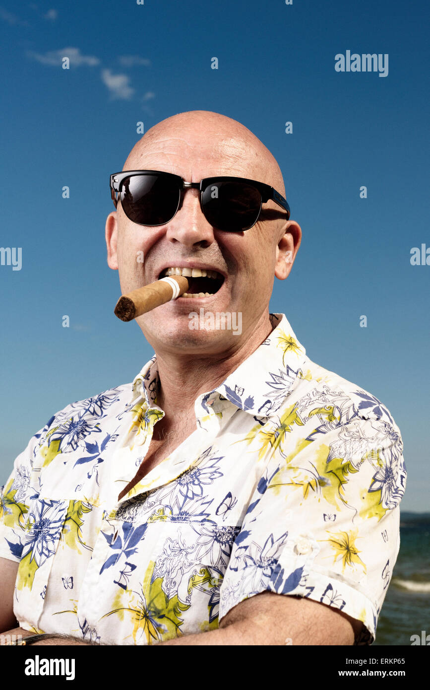 Mann in Hawaii Hemd, Sonnenbrille und Zigarre im Urlaub Stockfoto