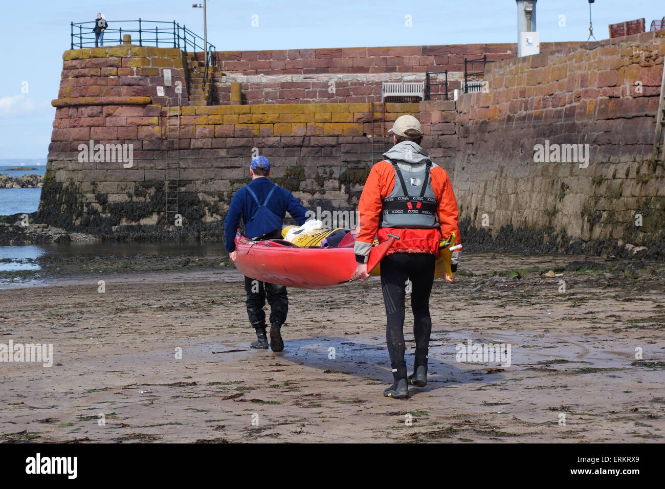 Kanuten tragen Seekajaks, Gewässerrand Stockfoto