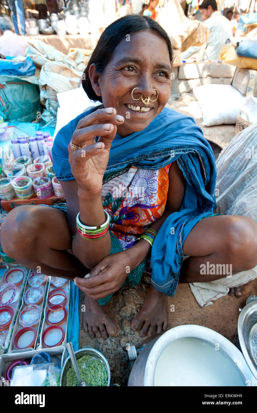 Lächelnd Mali Tribeswoman mit gold Noserings Verkauf von Joghurt in Mali Stammes-Wochenmarkt, Guneipada, Orissa (Odisha), Indien Stockfoto