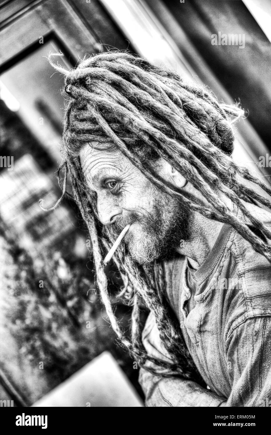 Rauchen Cannabis gemeinsamen Topf Pflanze Droge illegal Zigarettenrauch auf Straße Landstreicher Hippie Mann dreadlocks Stockfoto