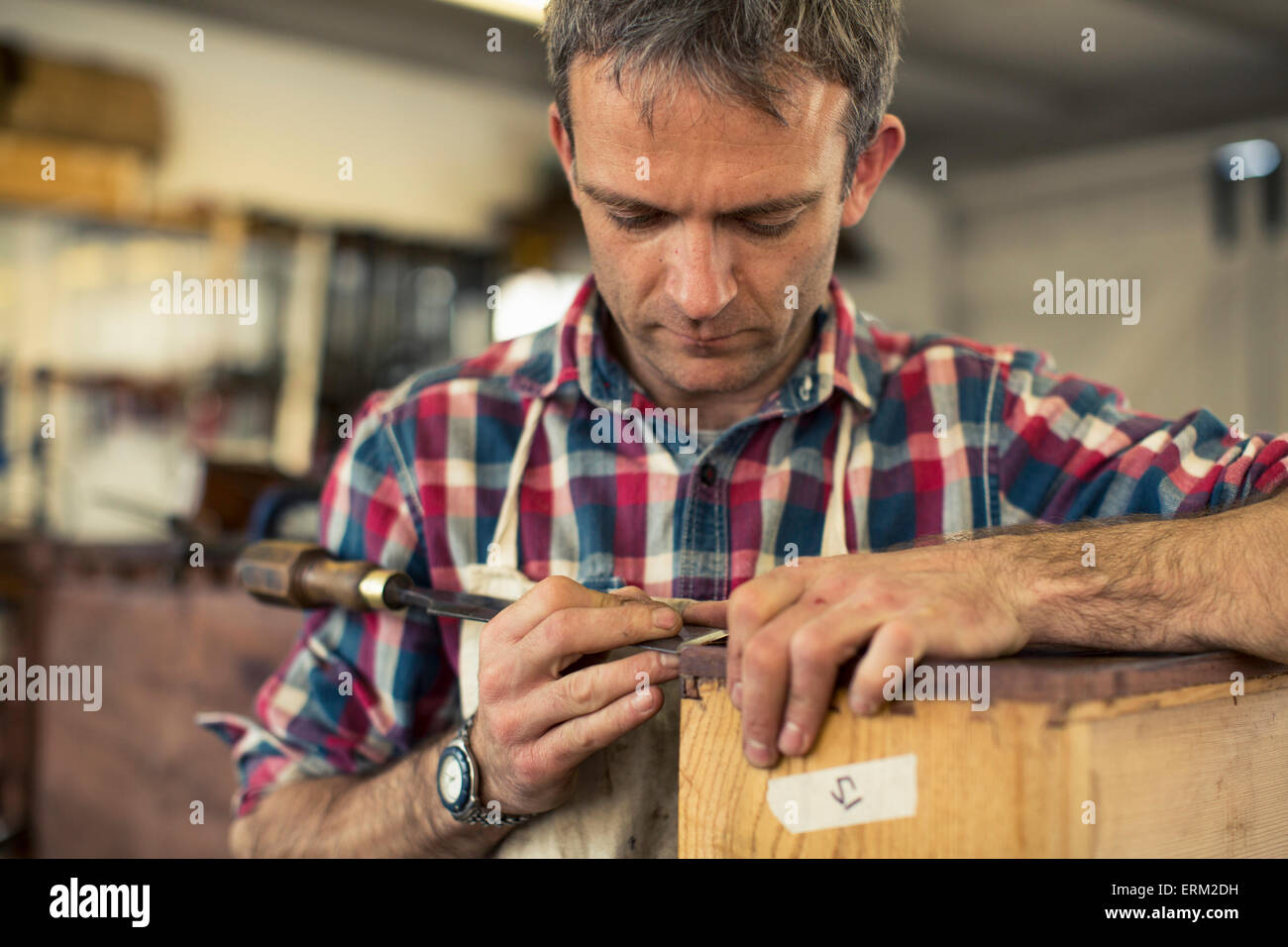 Eine antike Möbel-Restaurator arbeitet mit seinen Händen mit einem spitzen  Werkzeug am Rande ein Möbelstück aus Holz Stockfotografie - Alamy