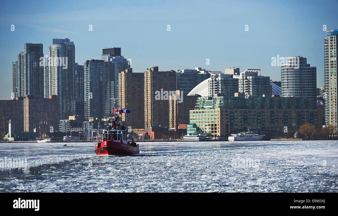 Fire Rescue Boot gegen die Skyline der Stadt vom Wards Island im Winter; Toronto, Ontario, Kanada Stockfoto