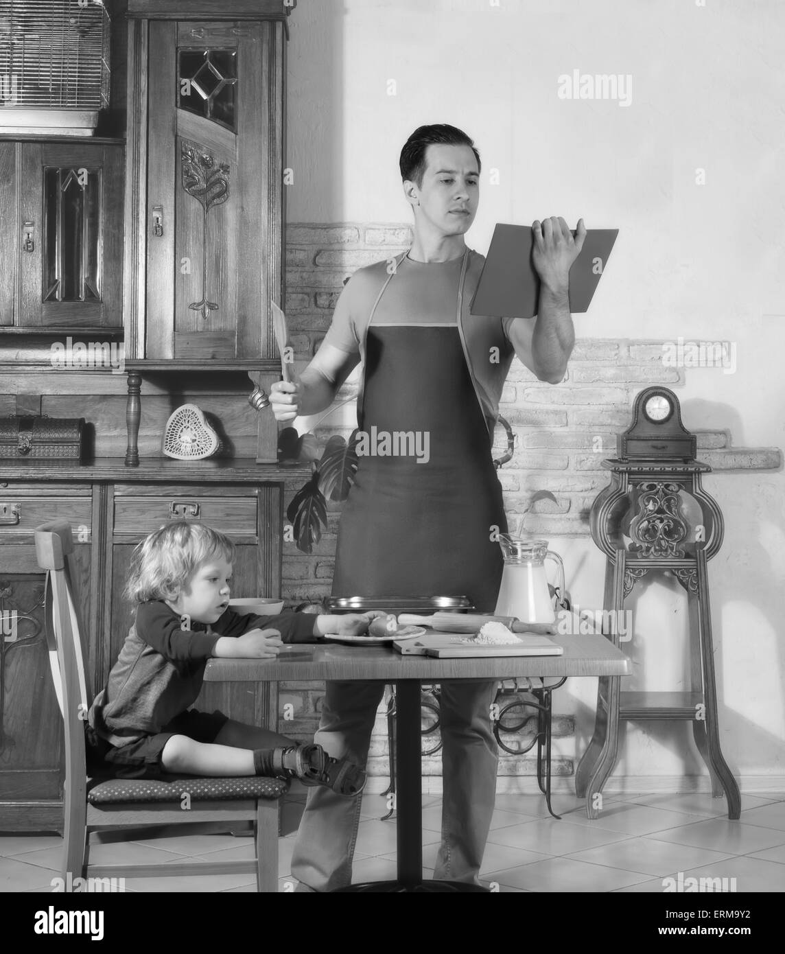 Mann mit kleinen Jungen in der Küche eine Mahlzeit zuzubereiten. Retro Stockfoto