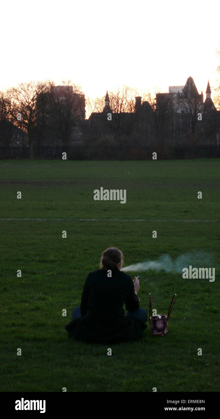 Ein Raucher ausatmet, während Sie den Sonnenuntergang genießen durch das königliche patriotischen Gebäude in Süd-London wandsworth Stockfoto