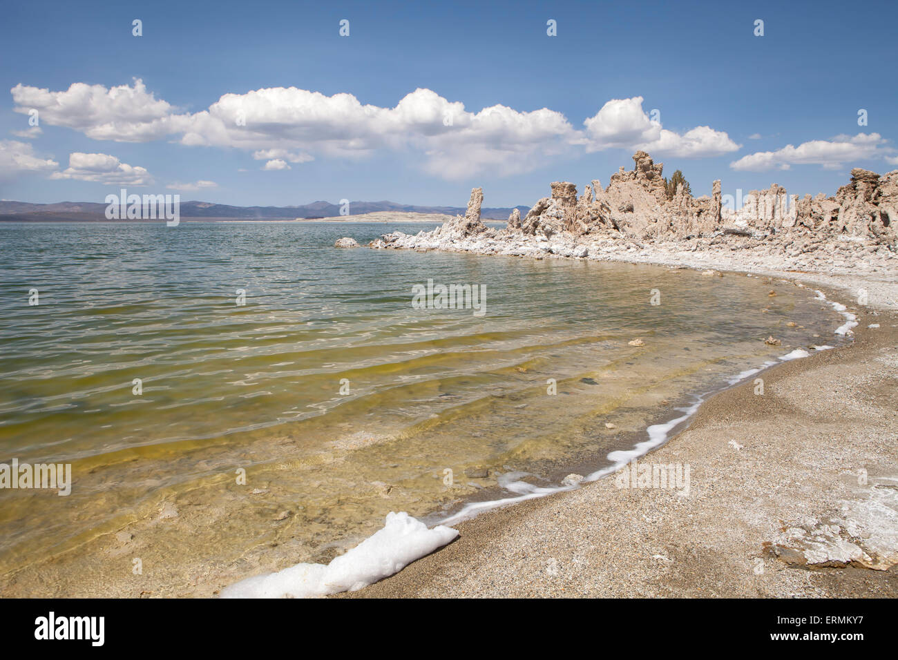 Wasser plätschern auf einem Strand des Mono Lake auf der östlichen Seite von den Sierras in Kalifornien an einem warmen Tag mit Wolken. Stockfoto