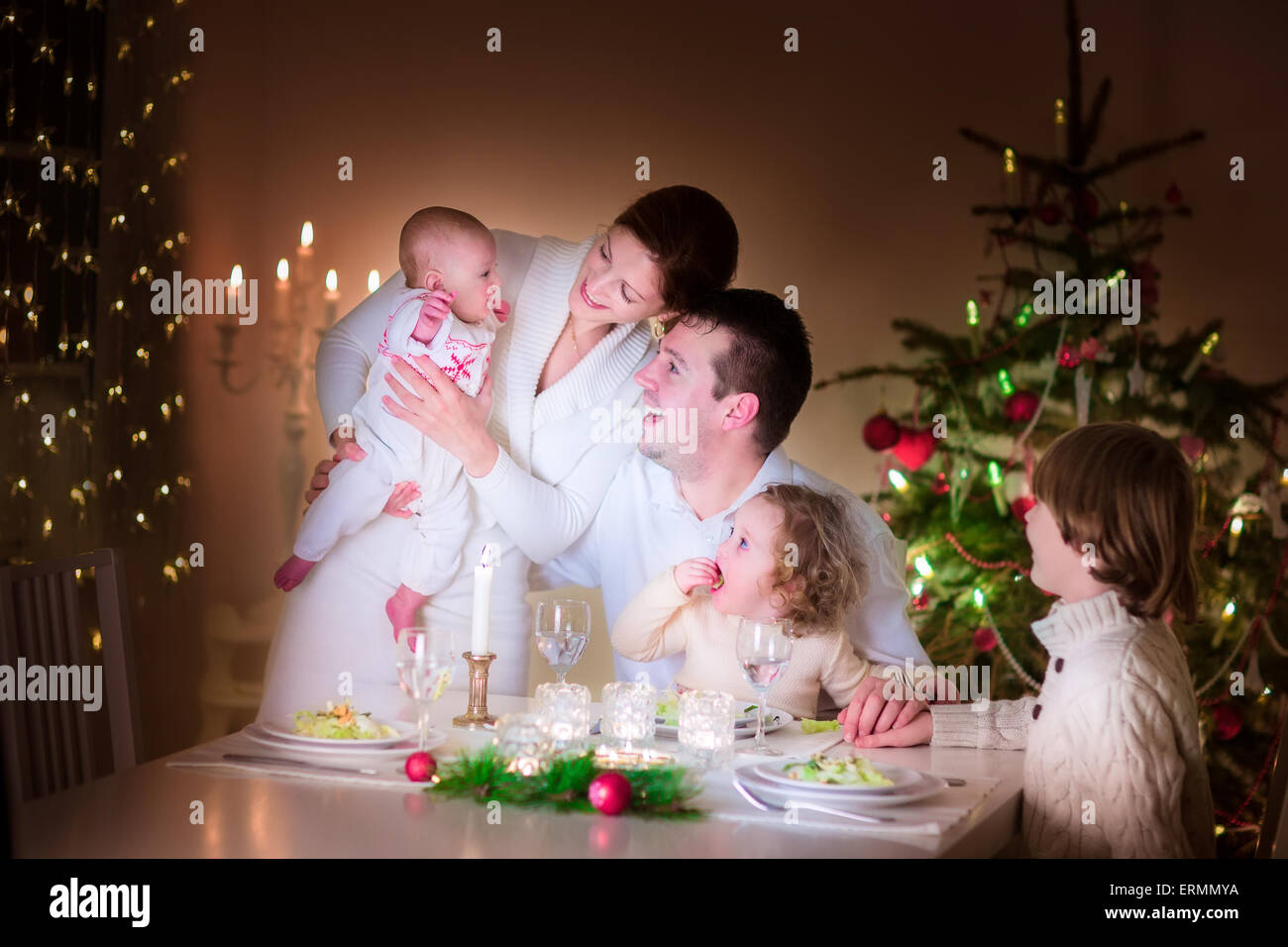 Große, glückliche junge Familie mit drei Kinder freuen sich über Weihnachten Abendessen Feier, Eltern und Kinder Stockfoto