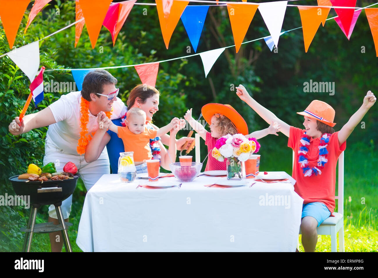 Große niederländische Familie mit Kindern feiern Nationalfeiertag oder Sport-Sieg, die Spaß am Grill-Party im Garten dekoriert mit Flagge Stockfoto