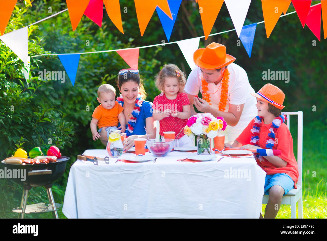 Große niederländische Familie mit Kindern feiern Nationalfeiertag oder Sport-Sieg, die Spaß am Grill-Party im Garten dekoriert mit Flagge Stockfoto