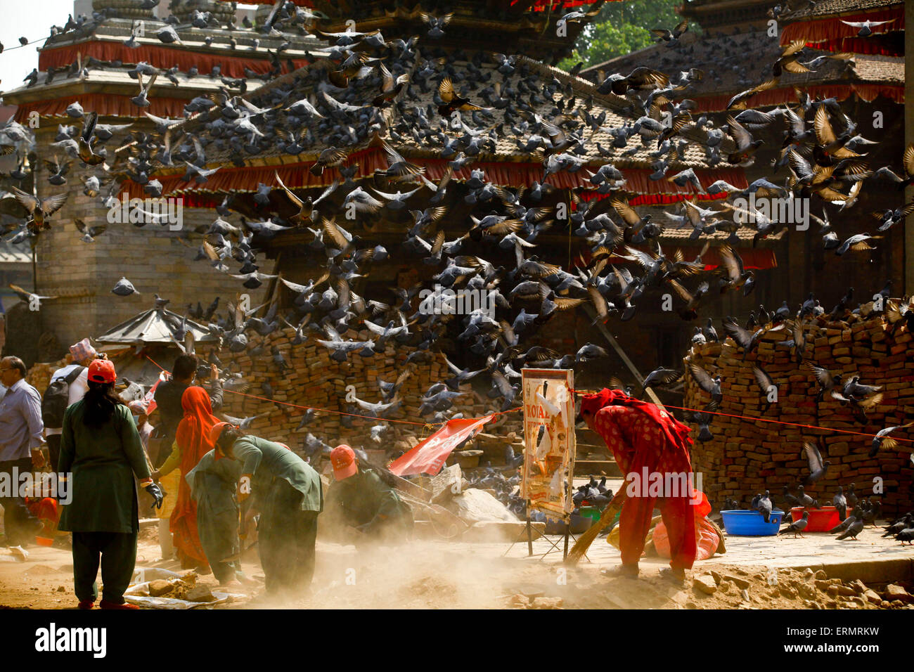 Kathamdnu, Nepal. 5. Juni 2015. Tauben fliegen, wie Frauen den Trümmern am Basantapur Durbar Square am Weltumwelttag in Kathmandu, Nepal, 5. Juni 2015 bereinigen. Welt-Umwelttag zeichnet sich jedes Jahr am 5. Juni, globales Bewusstsein positive ökologische Maßnahmen zum Schutz der Natur und der Erde zu wecken. Das diesjährige Thema ist "7 Milliarden Träume. Ein Planet. Mit Sorgfalt zu konsumieren ". © Pratap Thapa/Xinhua/Alamy Live-Nachrichten Stockfoto