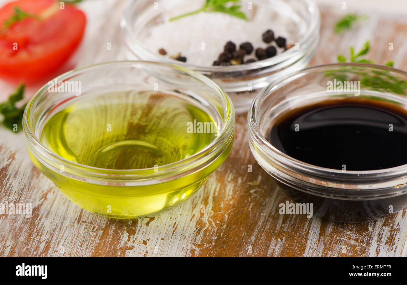 Schüssel mit Balsamico-Essig, Salz und Olivenöl auf einem Holztisch. Stockfoto