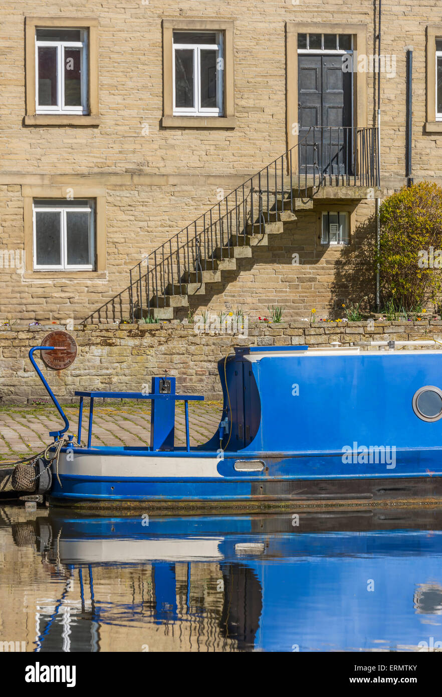 Blau lackierten Narrowboat vor Anker in der Nähe ein Sandsteingebäude Stockfoto