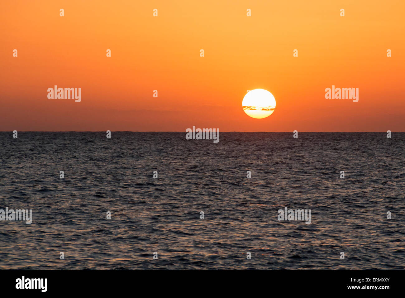 Glühende Sonne über das Meer und den Horizont bei Sonnenuntergang; Paphos, Zypern Stockfoto