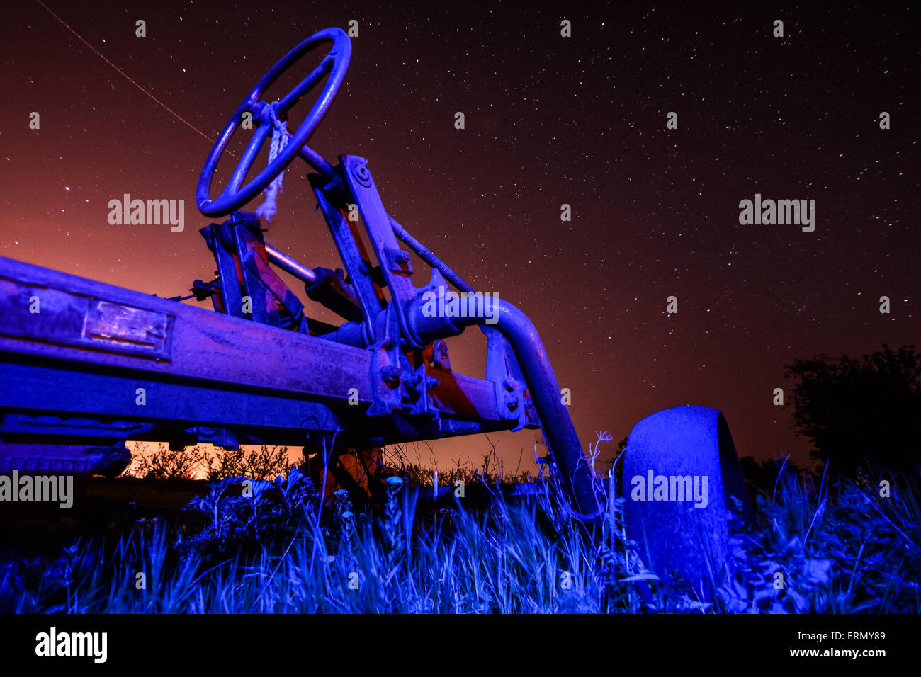 Lauf der Zeit Konzept - alten rostigen Traktor am Sternenhimmel Hintergrund Stockfoto