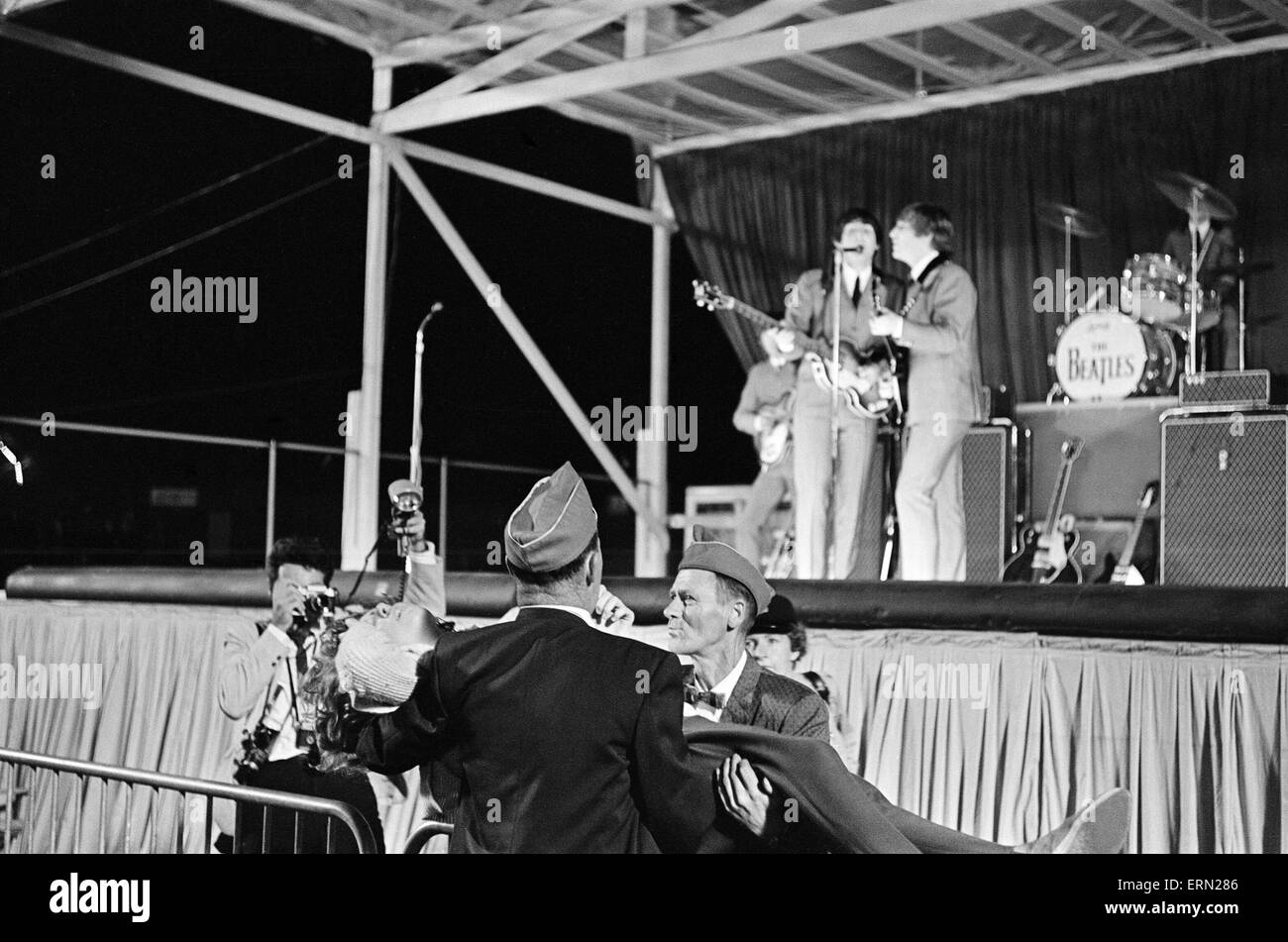 Die Beatles ersten Amerika-Tournee 19. August bis 20. September 1964. Die Band auf der Bühne im Empire Stadium in Vancouver, British Columbia, Kanada abgebildet, wie Fans geholfen werden. 22. August 1964. Stockfoto