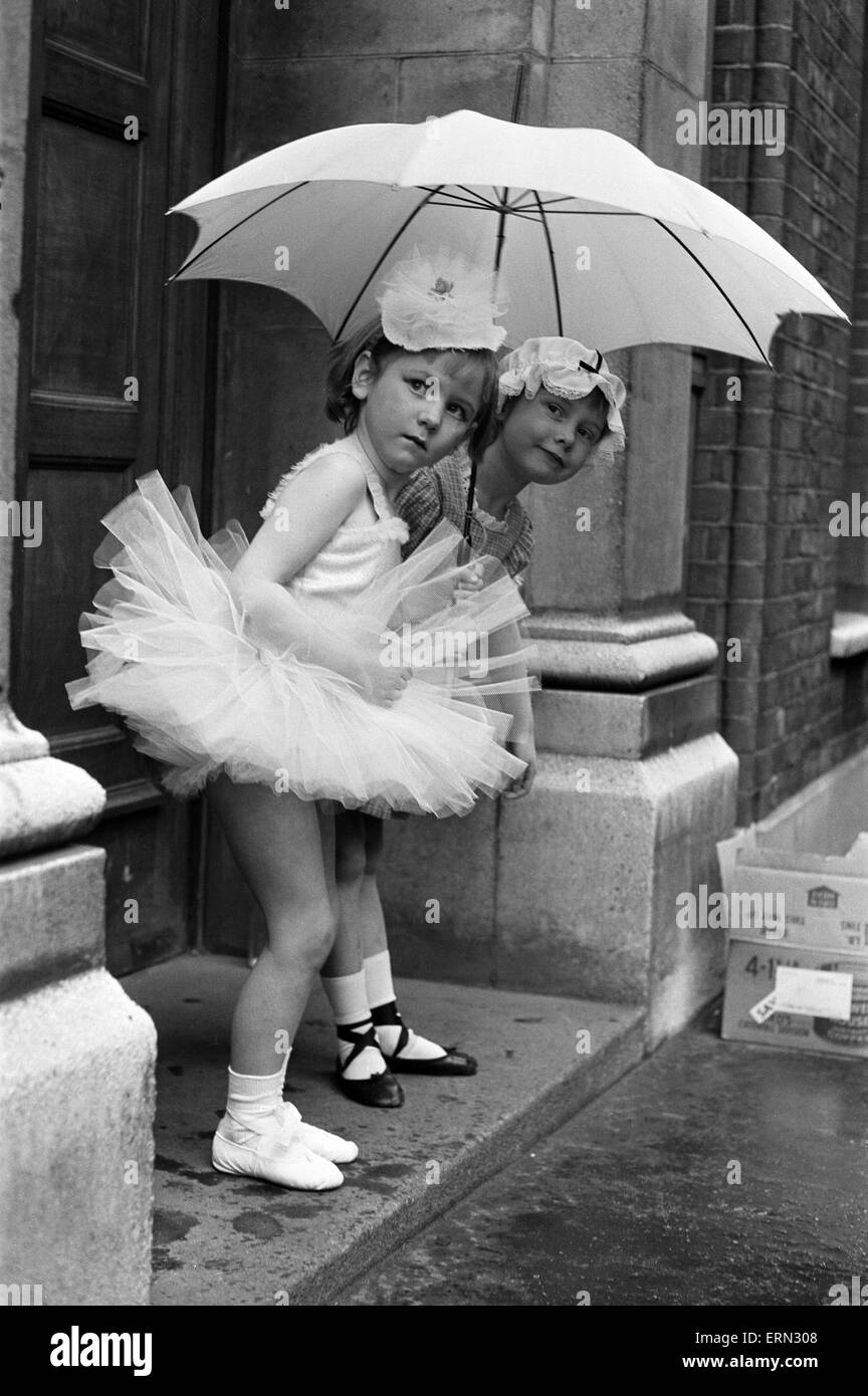 Warten Sie zwei Mädchen auf ihren Tanzlehrer in der Regen draußen ihre Ballett-Klasse. 1964 Stockfoto