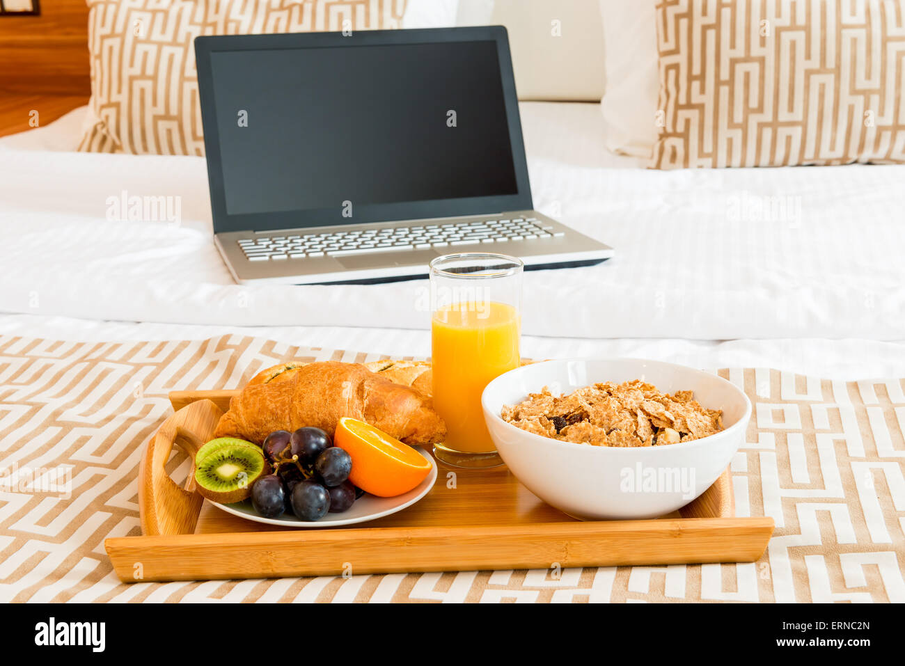 Frühstück im Bett und einen Laptop im Zimmer Stockfoto