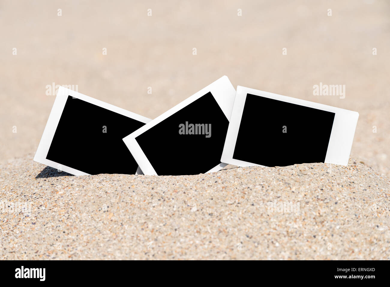 Leere Retro-Sofortbilder auf Strandsand im Sommer Stockfoto