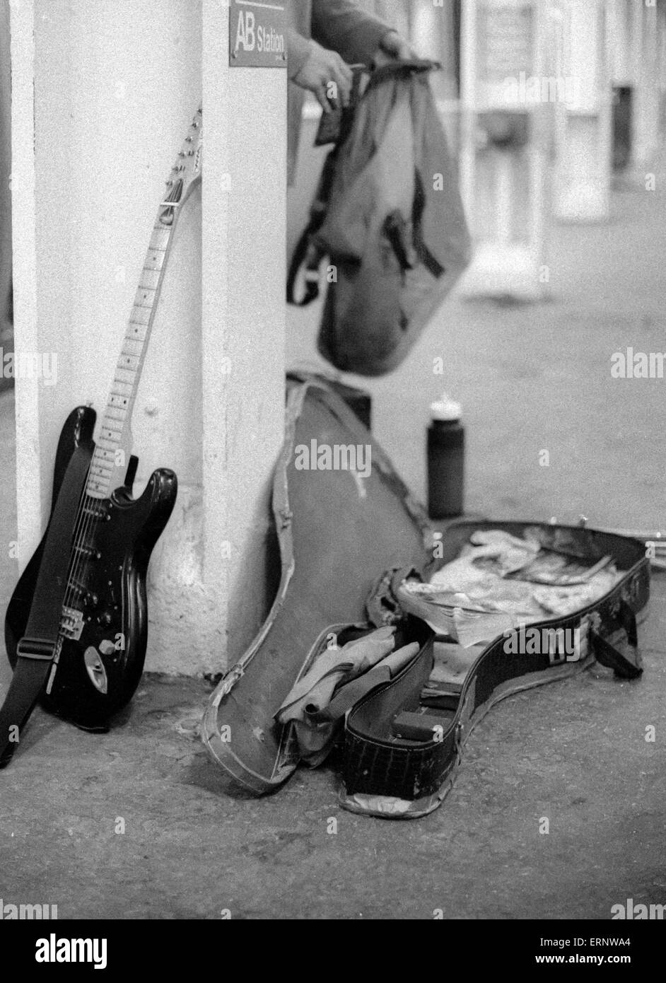 Chicago, IL, 22. Februar 1997: ein Straßenmusikant Gitarre und Gitarre Fall nach unten auf das blaue Linie u-Bahn / Bahnhof "Chicago". Stockfoto