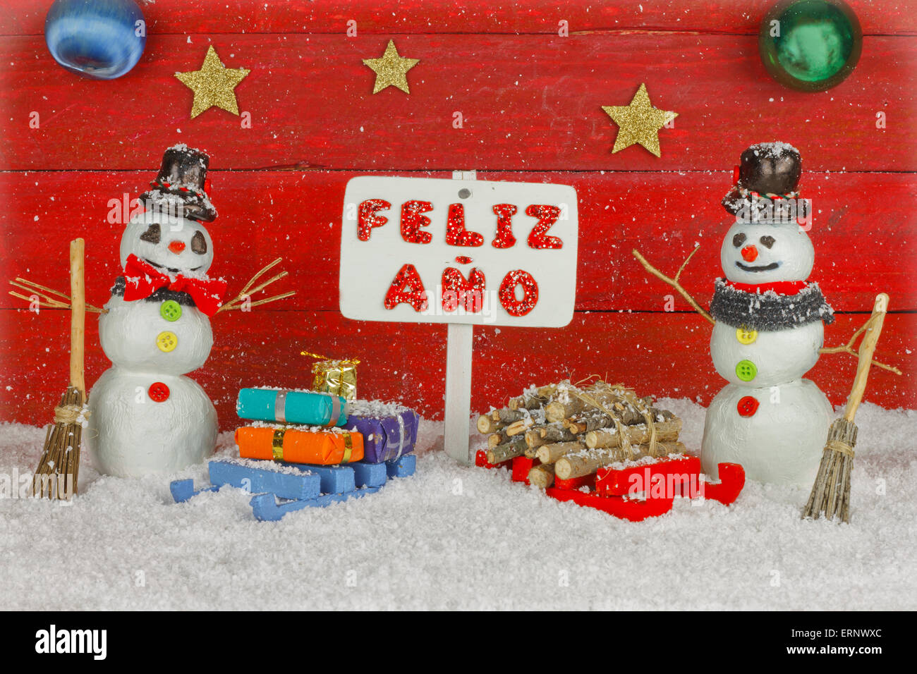 Zwei Schneemänner, die mit einem Schild mit den Worten Prosit Neujahr auf Spanisch Stockfoto