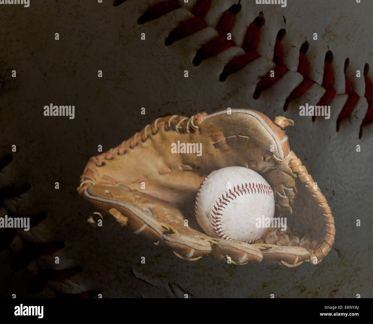 Ein abgenutzter Baseball sitzt im Inneren eines alten Baseballhandschuh mit dem Leder und Stiching eines Balls im Hintergrund.  Bild wurde durch u beleuchtet. Stockfoto