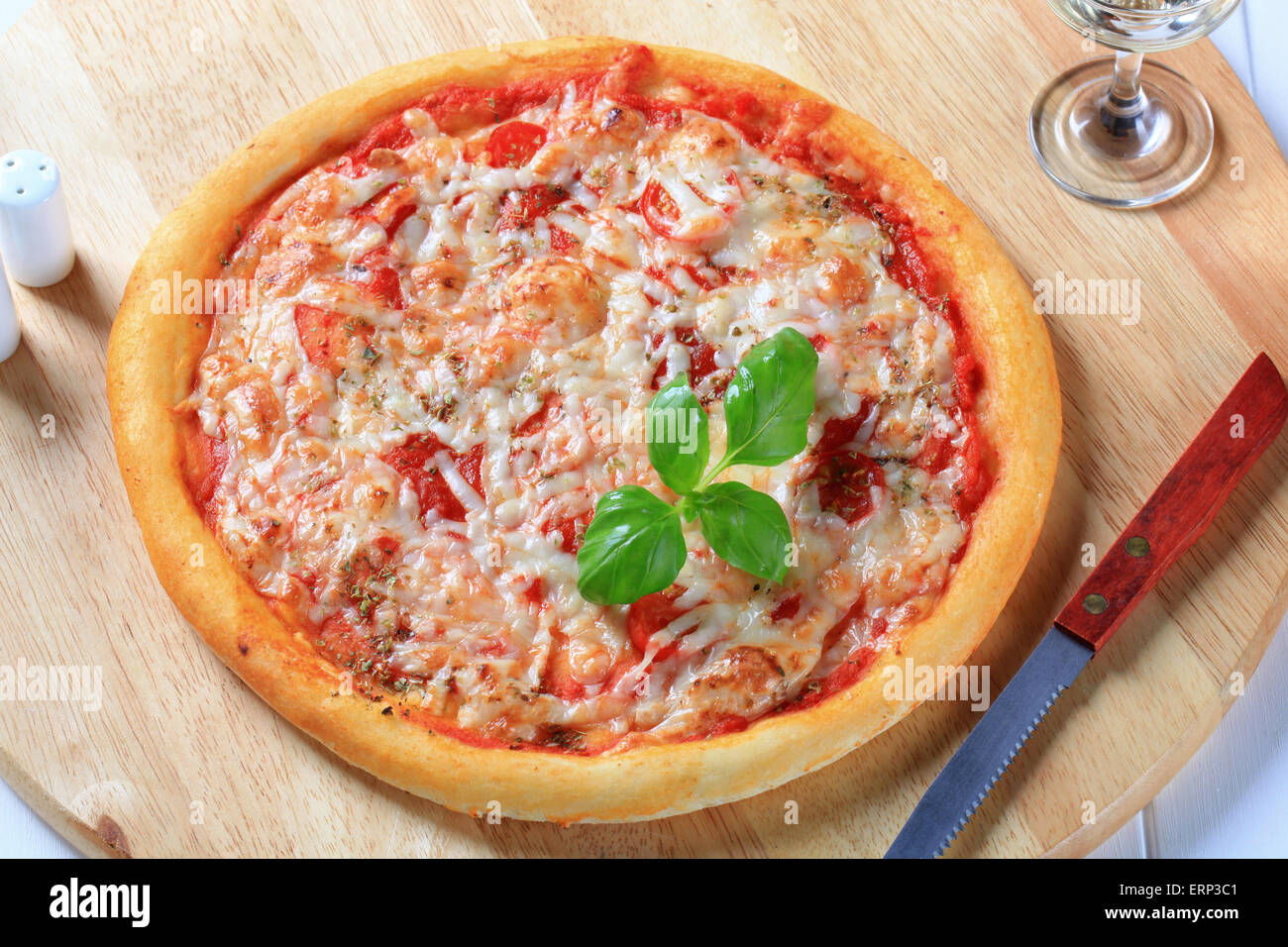Frisch gebackene Pizza Margherita und Glas Weißwein Stockfoto