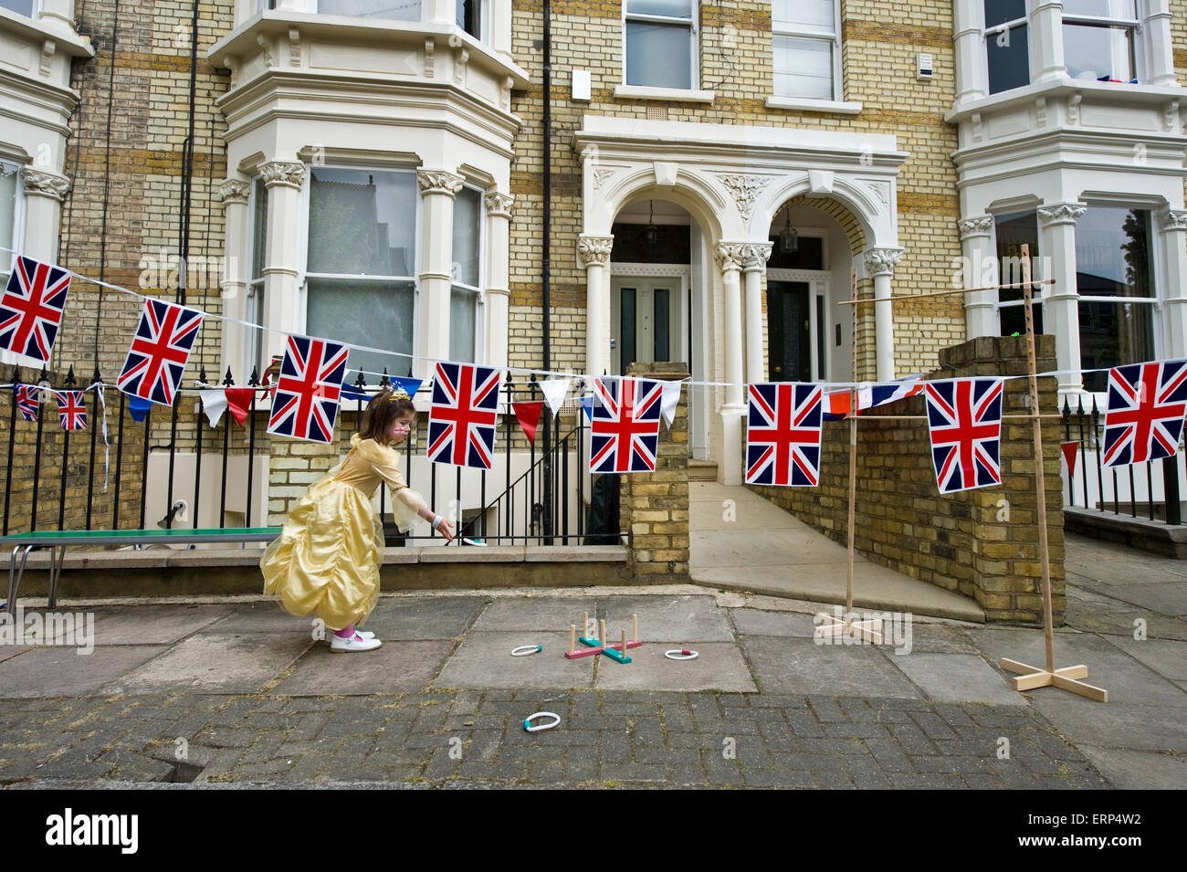 Ein kleines Mädchen spielt Quoits in einer Londoner Straße Partei mit Reihenhäusern und Union Jacks zur Feier der Geburt von Prince George Stockfoto