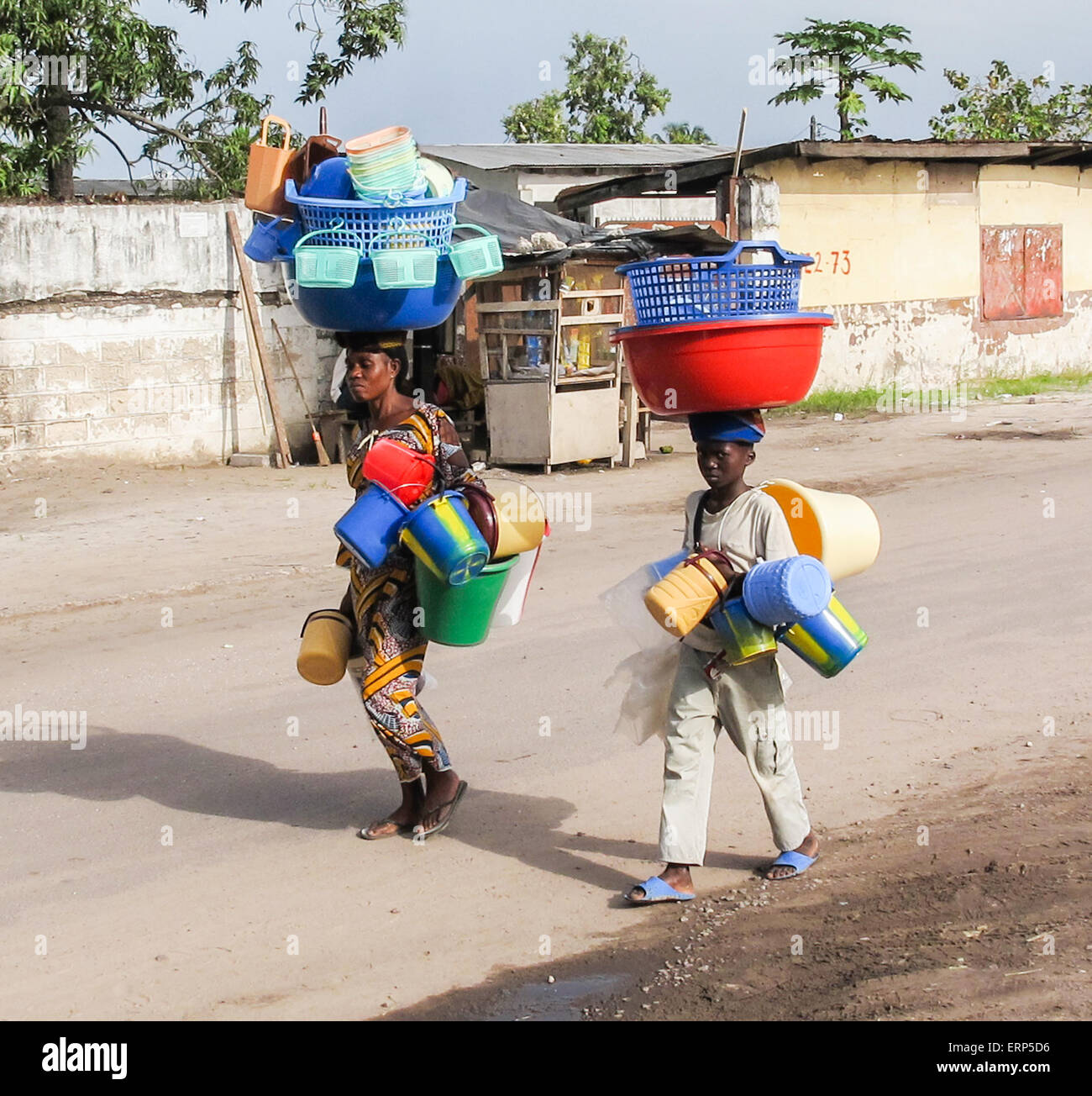 Eine afrikanische Frau und Kind in Brazzaville, der Hauptstadt der Republik Kongo Kunststoff Wassereimer auf ihren Köpfen tragen. Stockfoto