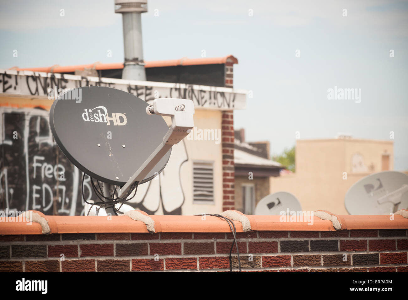 Dish Network Satellitenschüssel auf dem Dach eines Gebäudes im New Yorker Stadtteil Queens auf Donnerstag, 4. Juni 2015.  Die Teller-Netz, ein Satelliten-Fernsehen und Internet-Anbieter, wird berichtet, dass in Gesprächen mit Handy-Anbieter T-Mobile USA zu verschmelzen. Fernseh-und Kommunikation sind fortzuführen und verwischt die Grenze zwischen den Diensten. (© Richard B. Levine) Stockfoto