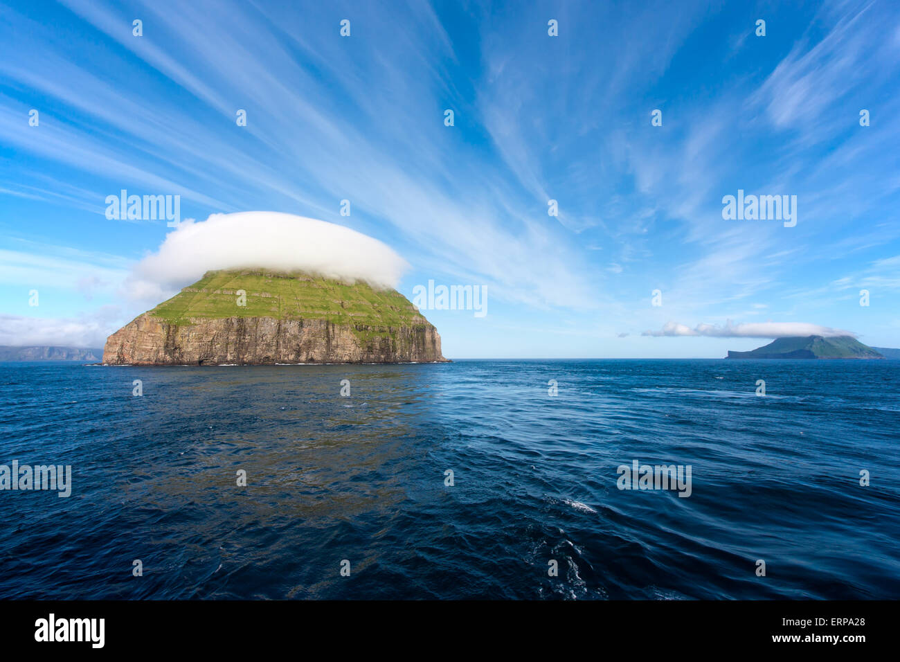 Unbewohnte Insel mit einer bizarren Obergrenze von Wolken Stockfoto