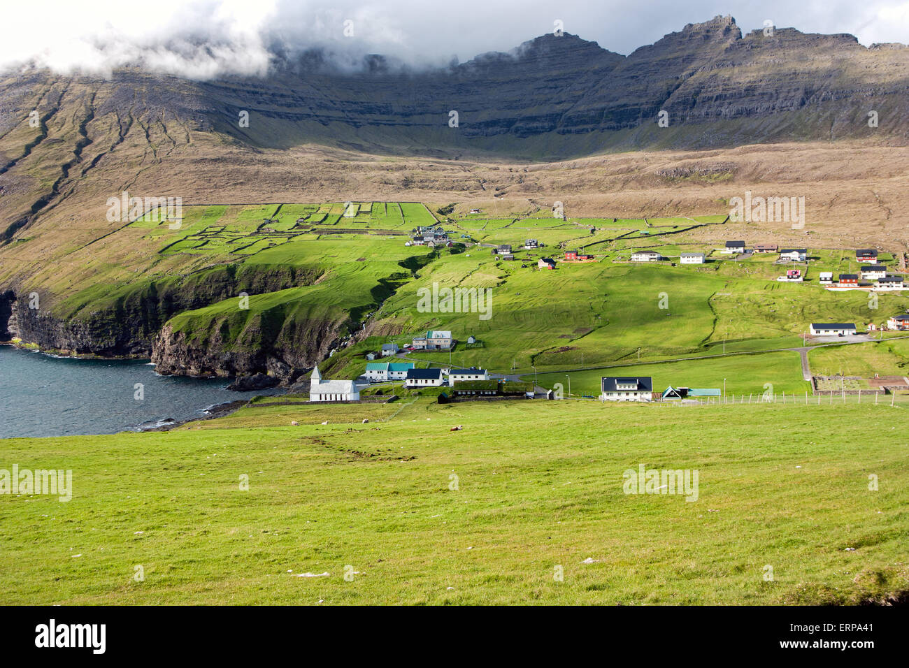 Färöer Inseln, kleinen Dorf in einem grünen Tal mit Blick aufs Meer Stockfoto