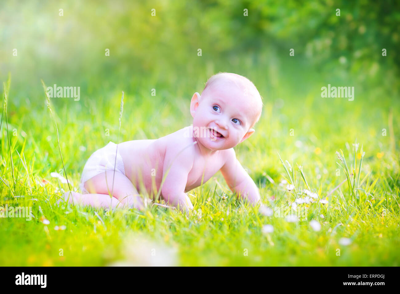 Lustige lachenden jungen tragen eine Windel Spaß im Garten lernen auf einer grünen Wiese mit Blumen an einem sonnigen Tag kriechen Stockfoto